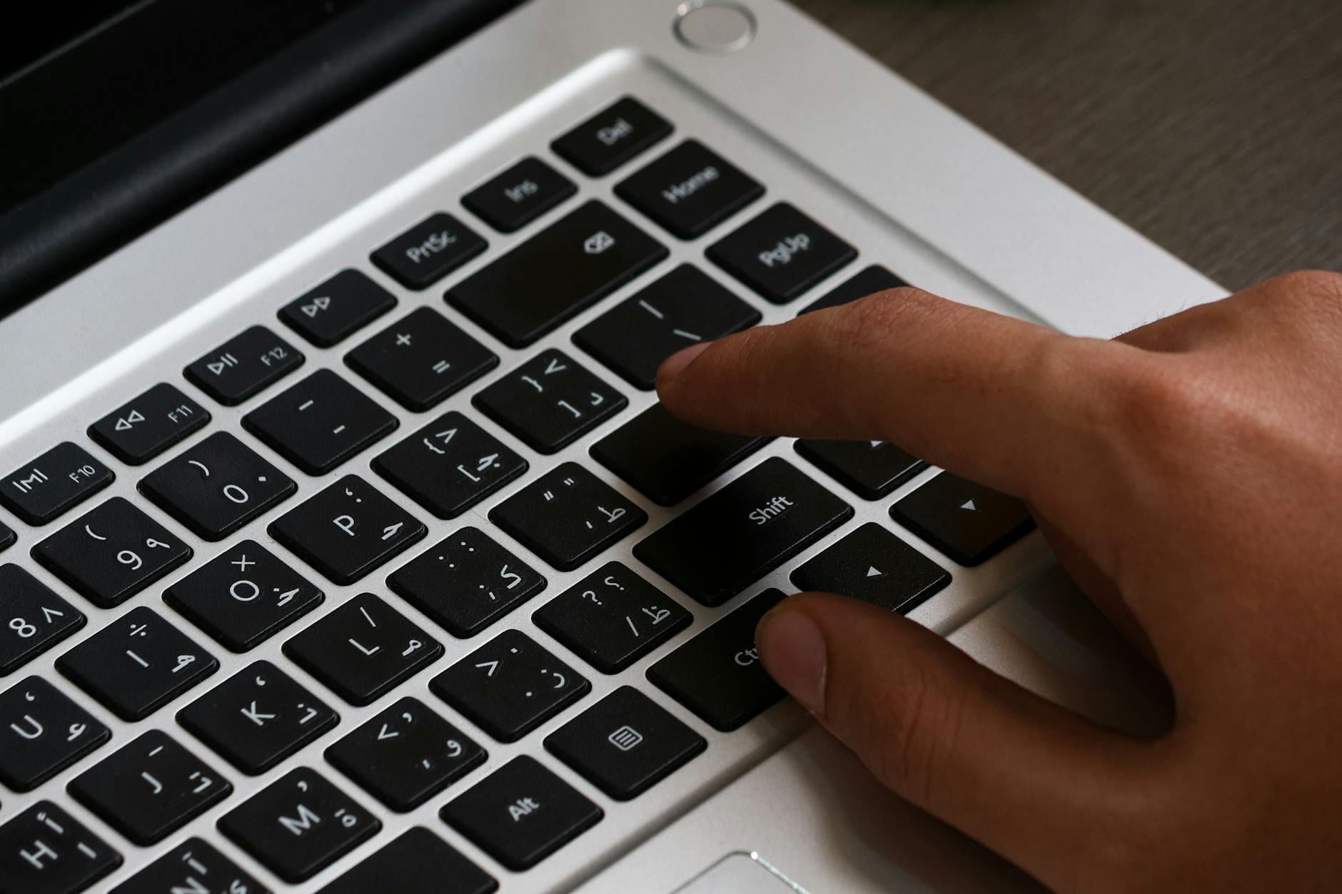 Pisanie bez patrzenia na klawiaturę: metody nauki i programy treningowe dla początkujących Dłoń pisząca na klawiaturze laptopa z arabskim układem klawiszy