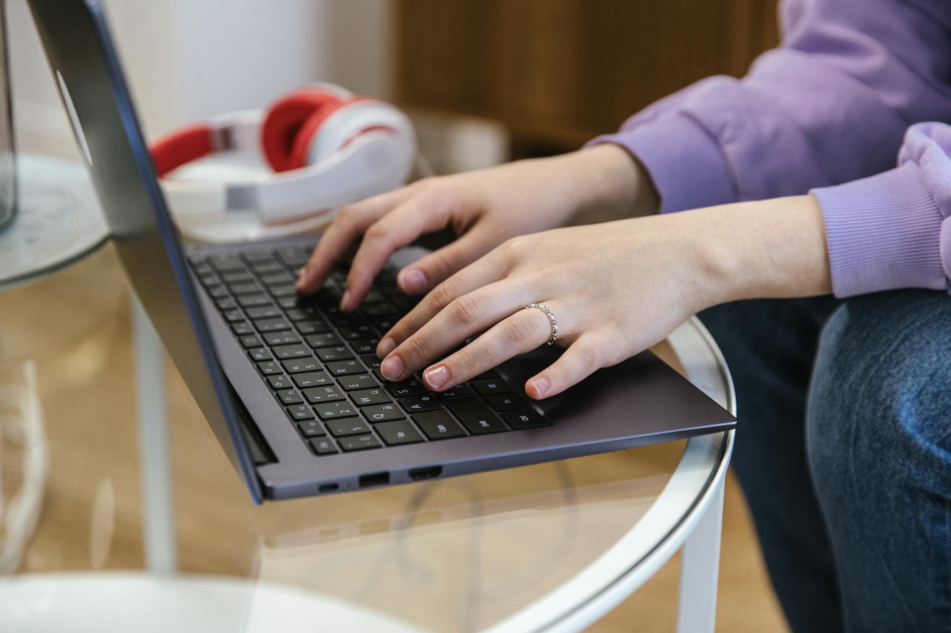Dłonie piszące na klawiaturze laptopa podczas nauki bezwzrokowego pisania