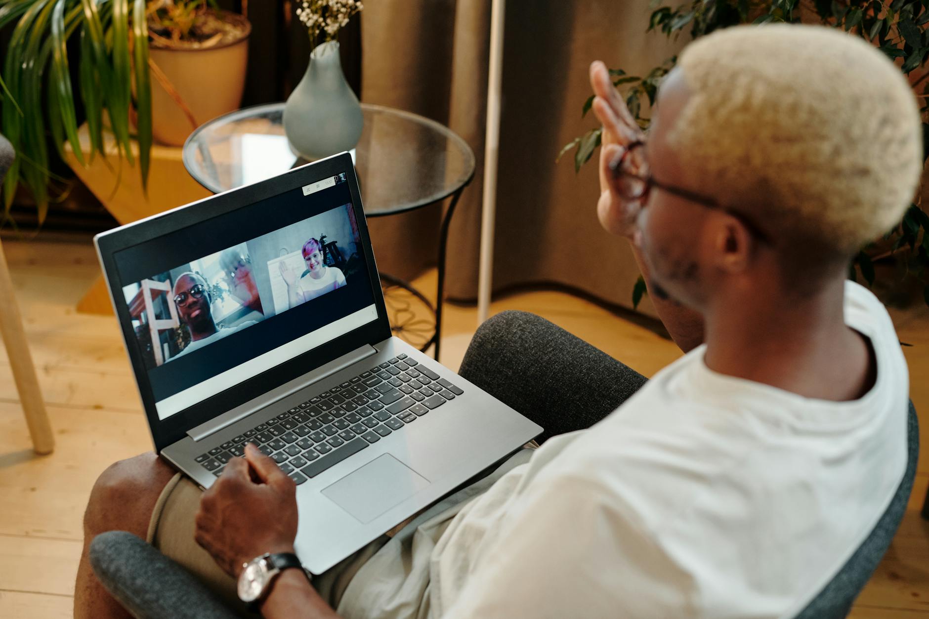 Mężczyzna prowadzi wideorozmowę na laptopie w domowym zaciszu
