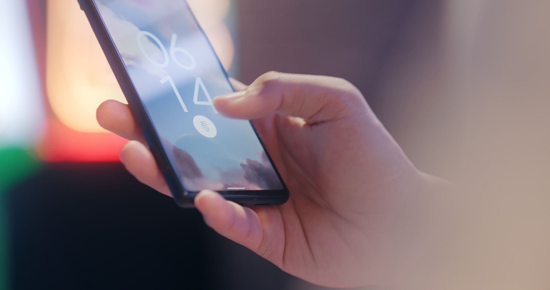 Dłoń trzymająca smartfon z zablokowanym ekranem i czytnikiem linii papilarnych