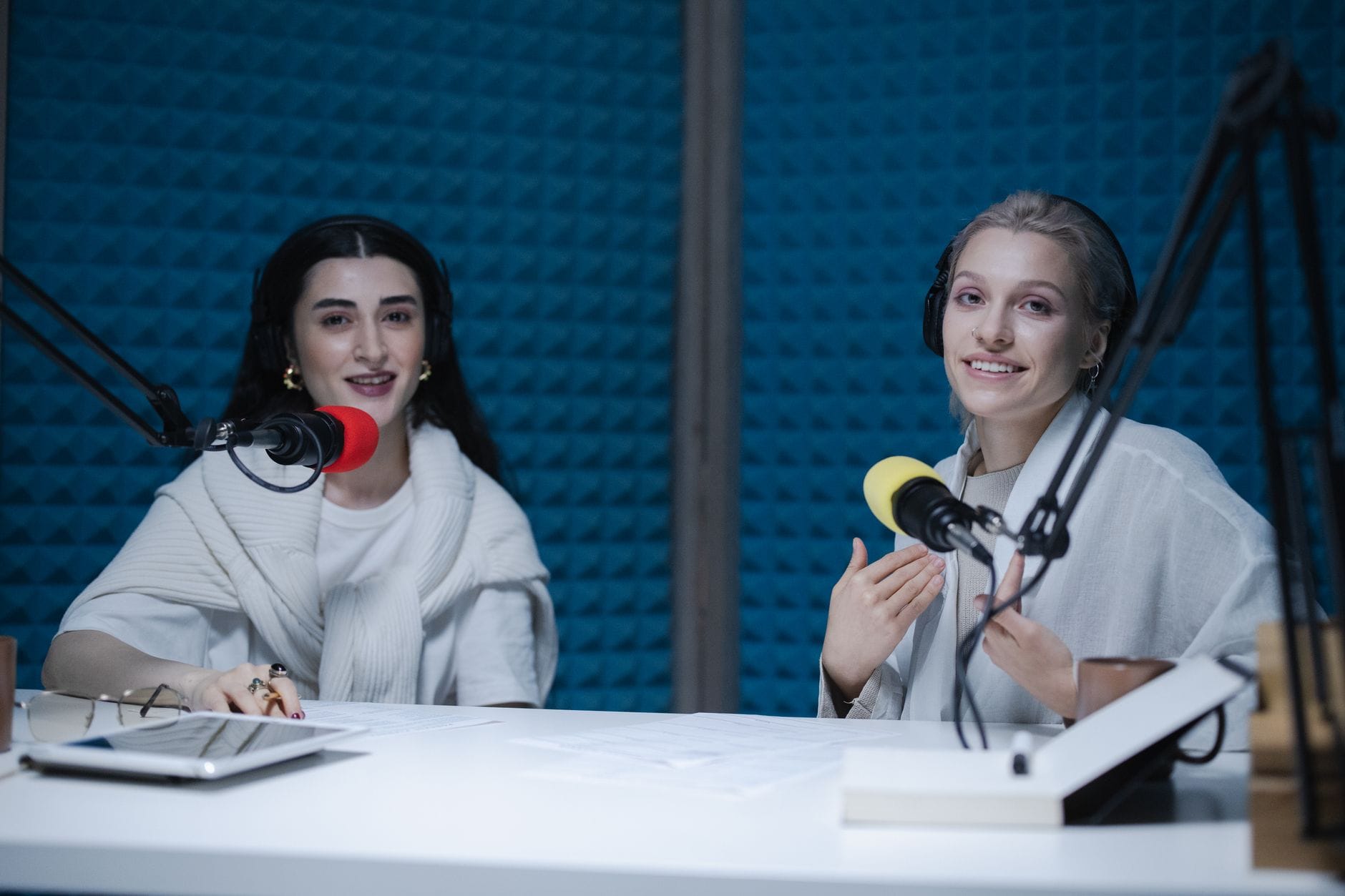 Dwie kobiety nagrywają podcast w nowoczesnym studiu nagraniowym