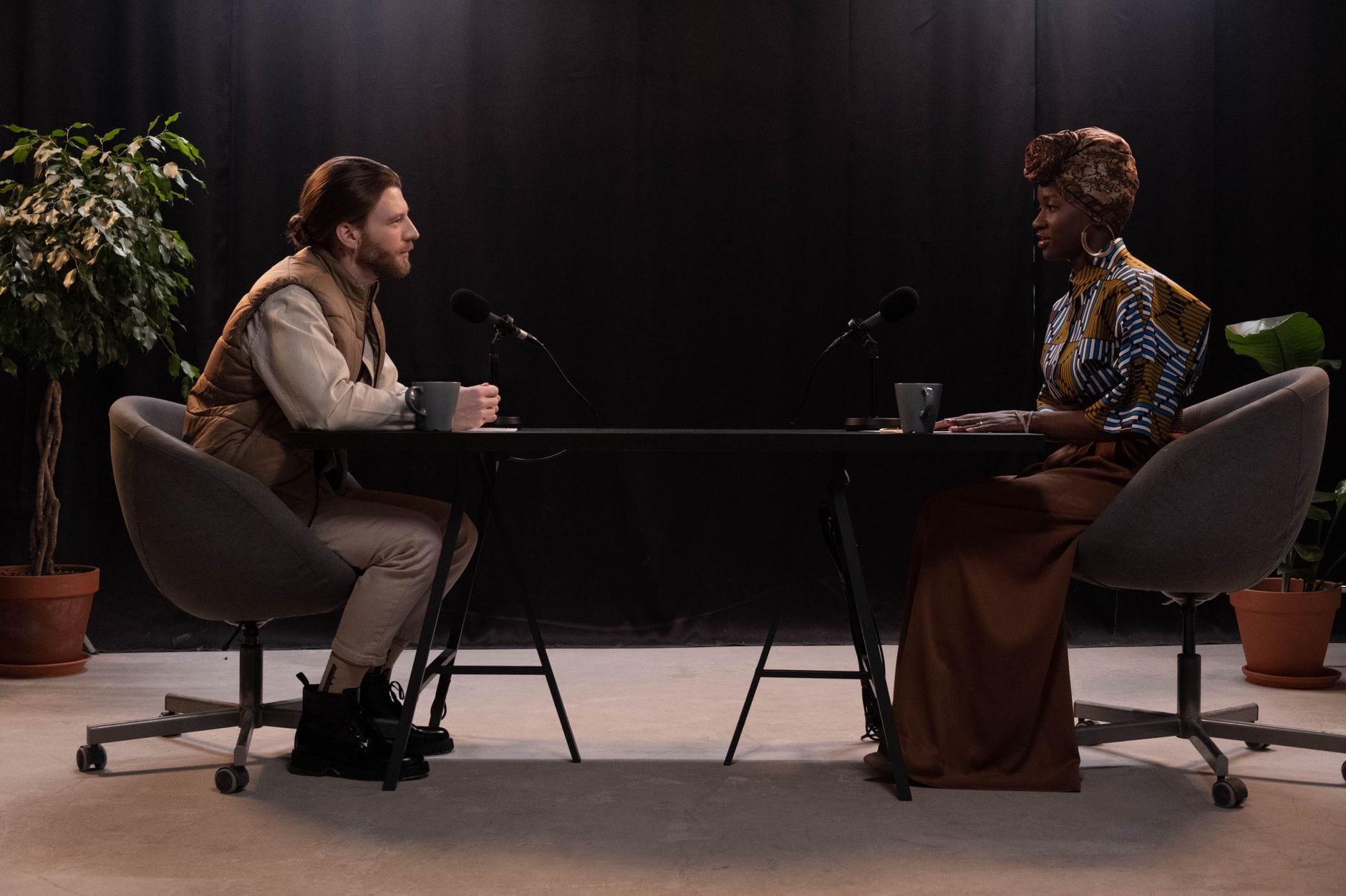 Dwie osoby nagrywają rozmowę podcastową w studiu z mikrofonami