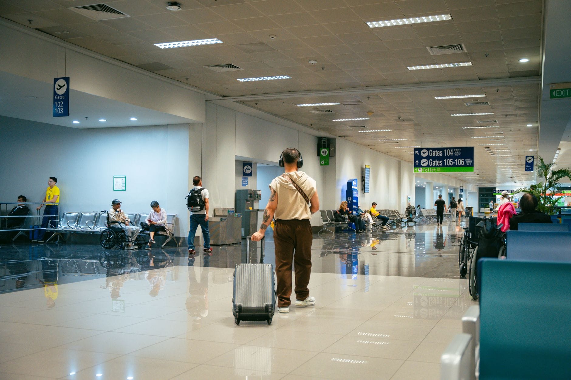 Pasażerowie czekający w przestronnym terminalu lotniska Pasażerowie czekający w przestronnym terminalu lotniska