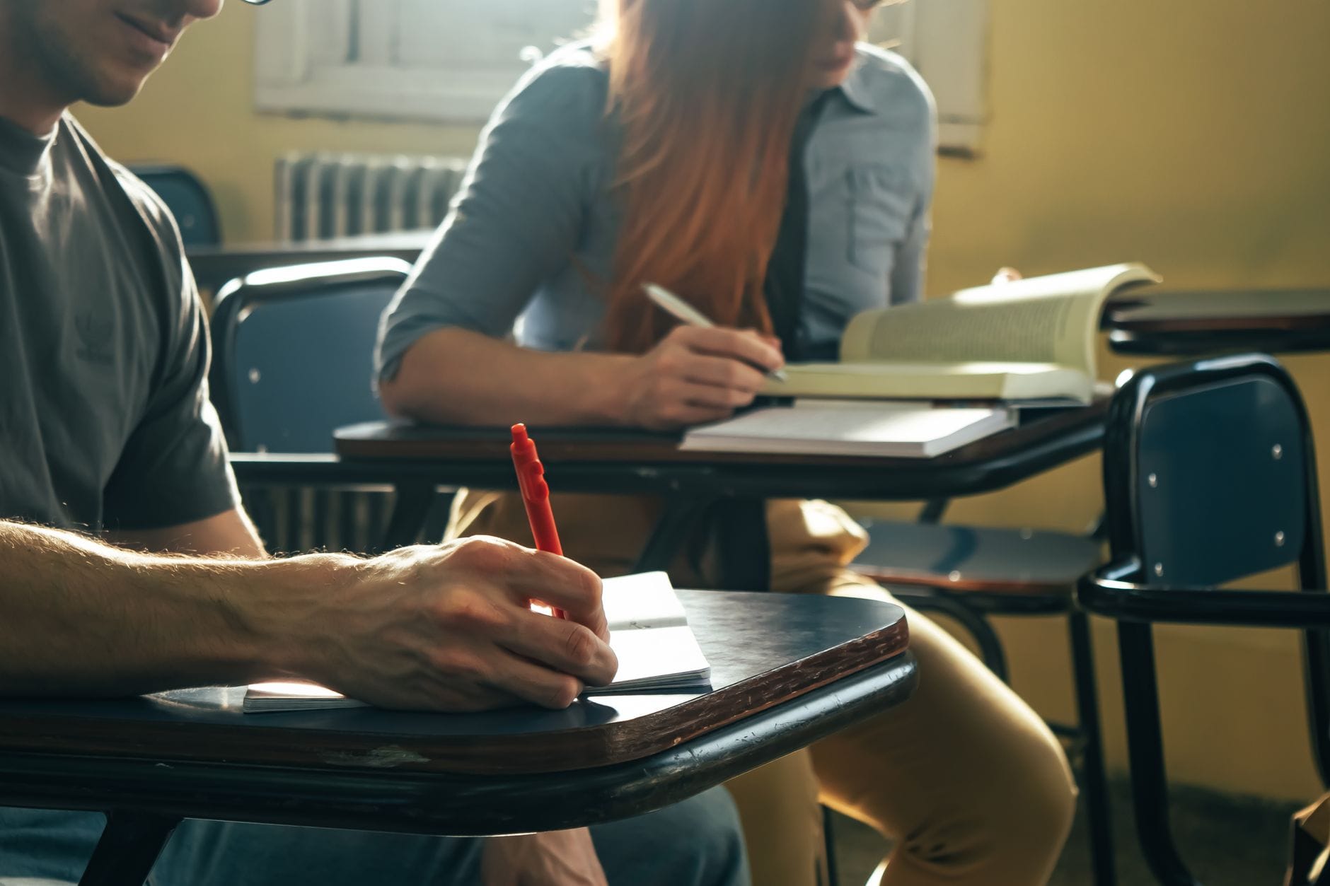 Uczniowie robią notatki i czytają podczas wspólnej nauki w domu