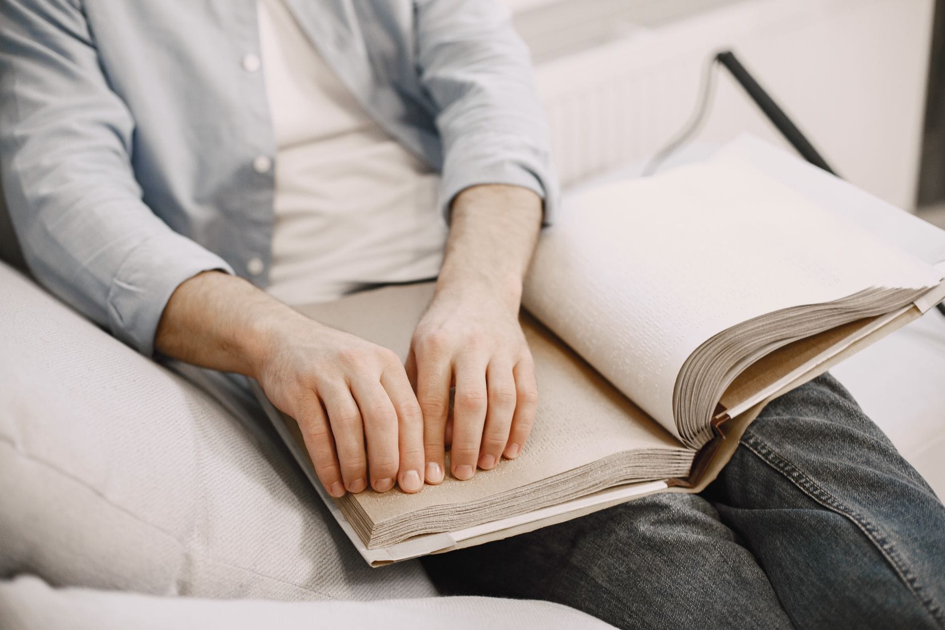 Czytniki e-booków przyjazne osobom słabowidzącym: funkcje, które naprawdę mają znaczenie Osoba dorosła czyta książkę brajlowską, świadomość wzroku i dostępności