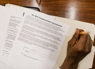 Dodatkowy urlop i 7-godzinny dzień pracy: prawa pracownika z orzeczeniem Podpisywanie umowy o pracę przy drewnianym biurku